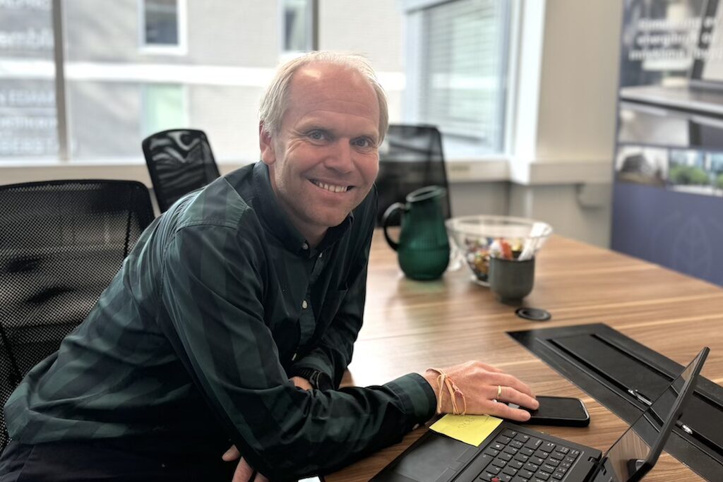Mann sitter ved kontorpulten