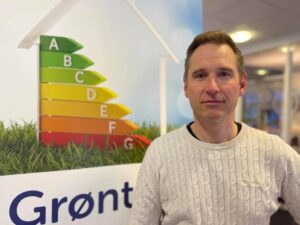 Mann foran skilt som viser energimerking